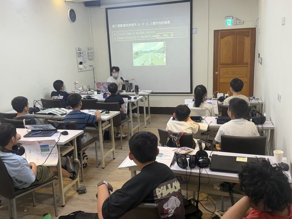台中南屯教室營隊課堂，老師在投影幕前講解程式碼，學生看著螢幕聽講