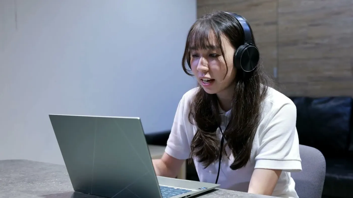 線上課的老師端實際畫面：老師戴著耳麥、面對筆記型電腦進行線上授課
